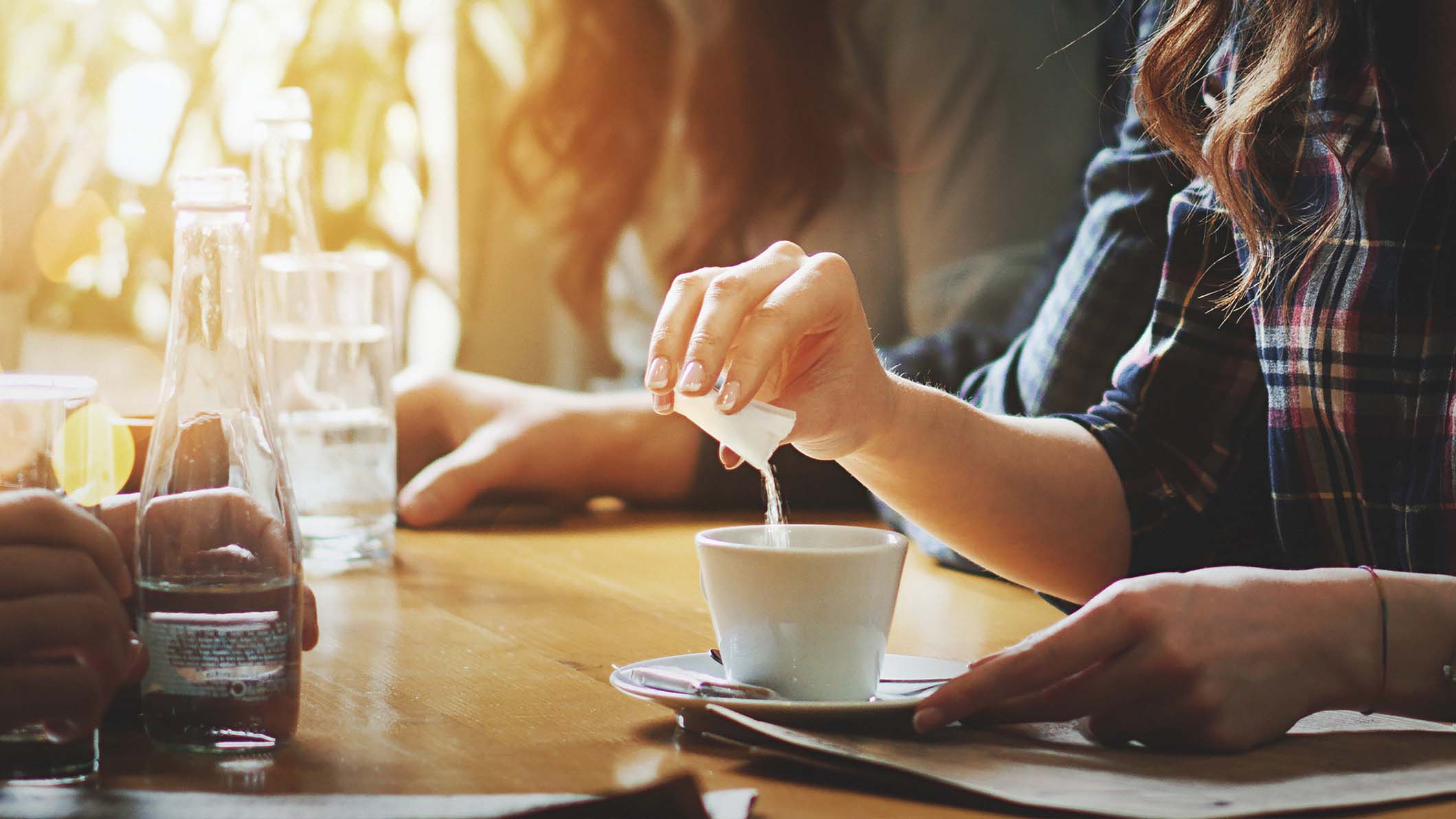 a woman pouring a liquid into a cup