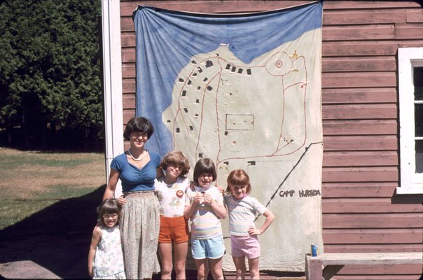 Children and an adult posing for a photo at camp 