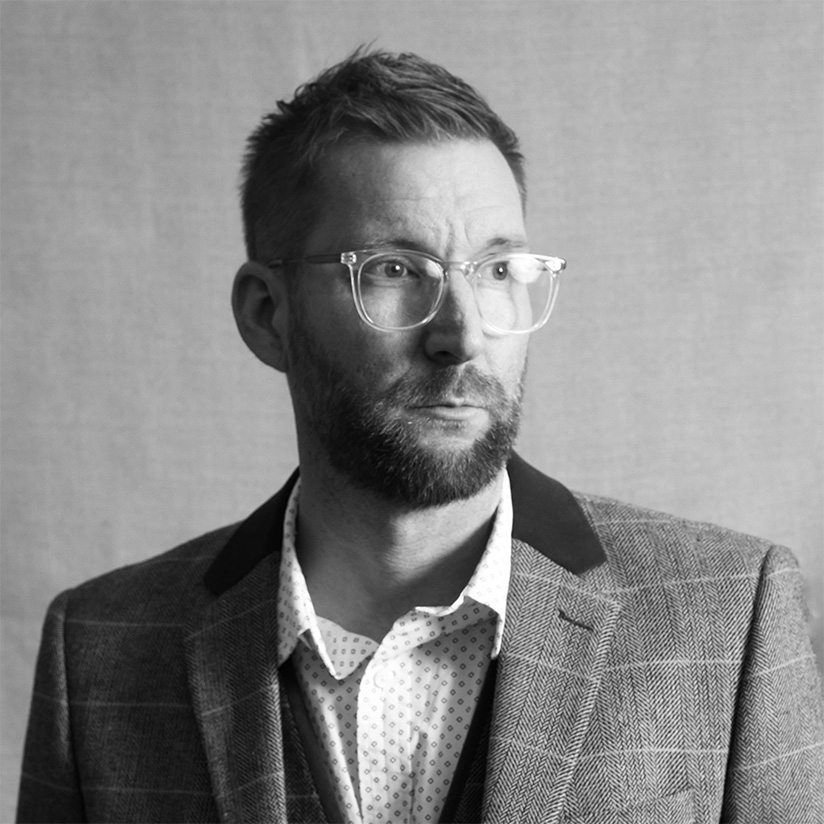 a man wearing glasses and a suit